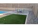 Backyard patio with artificial turf, desert landscaping, and dining area for relaxation at 31138 N 130Th Ln, Peoria, AZ 85383