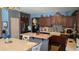 Well-lit kitchen featuring an island with seating, granite countertops, and wooden cabinetry at 31138 N 130Th Ln, Peoria, AZ 85383