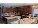 Open-concept kitchen with granite countertops, wood cabinets, and a farmhouse sink at 31138 N 130Th Ln, Peoria, AZ 85383