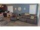 Living room with plush seating, carpet, and modern decor, adjacent to the kitchen and dining areas at 31138 N 130Th Ln, Peoria, AZ 85383