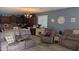 Cozy living room with plush seating, carpet, and modern decor, adjacent to the kitchen and dining areas at 31138 N 130Th Ln, Peoria, AZ 85383