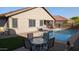 Relaxing backyard pool area with a dining table, chairs, and well-kept landscaping at 31138 N 130Th Ln, Peoria, AZ 85383
