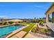 Lush backyard with a refreshing pool, comfortable hammock, and vibrant landscaping at 3125 W Desert Ln, Laveen, AZ 85339