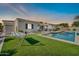 Lush backyard features artificial turf, a swimming pool, and a cozy hammock for outdoor relaxation at 3125 W Desert Ln, Laveen, AZ 85339