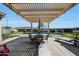 Inviting backyard patio with pergola, dining set, pool and beautifully landscaped yard at 3125 W Desert Ln, Laveen, AZ 85339
