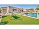 Lush backyard features artificial turf, a swimming pool, and a cozy hammock for outdoor relaxation at 3125 W Desert Ln, Laveen, AZ 85339