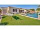 Expansive backyard featuring a sparkling pool, artificial turf, and comfortable seating, creating a serene outdoor retreat at 3125 W Desert Ln, Laveen, AZ 85339