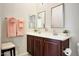 Bright bathroom features double sinks, square mirrors, and neutral-toned walls at 3125 W Desert Ln, Laveen, AZ 85339