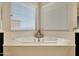 Corner bathtub with decorative accents by two large windows with bright neutral decor at 3125 W Desert Ln, Laveen, AZ 85339