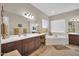 A spacious bathroom features a soaking tub, a vanity with seating and multiple mirrors reflecting the space at 3125 W Desert Ln, Laveen, AZ 85339
