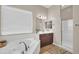 Bright bathroom featuring a soaking tub, a walk-in shower, and a vanity with warm lighting at 3125 W Desert Ln, Laveen, AZ 85339