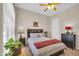 A well-lit bedroom features a neat bed, ceiling fan, and a window, conveying a sense of cozy comfort at 3125 W Desert Ln, Laveen, AZ 85339