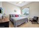 Bright bedroom with a large window, patterned bedspread, and comfortable seating at 3125 W Desert Ln, Laveen, AZ 85339