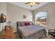 Well-lit bedroom featuring a ceiling fan and a large window overlooking the neighborhood at 3125 W Desert Ln, Laveen, AZ 85339