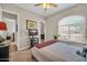 Sunlit bedroom showing doorway to bath, neutral walls, a large window, and a neat, simply decorated bed at 3125 W Desert Ln, Laveen, AZ 85339