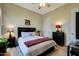 Cozy bedroom with a ceiling fan, carpet flooring, and a comfortable-looking bed with a red throw blanket at 3125 W Desert Ln, Laveen, AZ 85339