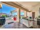 Spacious covered patio with comfortable seating and a view of the sparkling pool and landscaped backyard at 3125 W Desert Ln, Laveen, AZ 85339