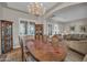 Elegant dining room with wood table, chandelier, and seamless transition into a well-appointed living space at 3125 W Desert Ln, Laveen, AZ 85339
