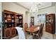 Elegant dining room features a chandelier, wood table, and built-in cabinets with decorative items at 3125 W Desert Ln, Laveen, AZ 85339
