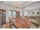 Elegant dining room featuring a wooden table, decorative chandelier, and seamless flow to living areas at 3125 W Desert Ln, Laveen, AZ 85339