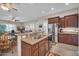 Open kitchen boasts stainless steel appliances, granite counters, and a breakfast bar overlooking the living area at 3125 W Desert Ln, Laveen, AZ 85339