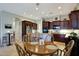Open kitchen with dark cabinets, granite countertops, and attached breakfast nook seating at 3125 W Desert Ln, Laveen, AZ 85339