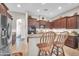 Stylish kitchen featuring dark wood cabinets, granite counters, and breakfast bar at 3125 W Desert Ln, Laveen, AZ 85339