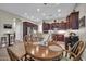 Eat-in kitchen area with a round wooden table and chairs, complemented by dark wood cabinetry and granite counters at 3125 W Desert Ln, Laveen, AZ 85339