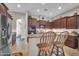 Spacious kitchen featuring wood cabinets, granite countertops, breakfast bar, and stainless steel appliances at 3125 W Desert Ln, Laveen, AZ 85339