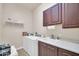 This laundry room has a washer and dryer, sink, lots of cabinet space, and a shelf for extra storage at 3125 W Desert Ln, Laveen, AZ 85339
