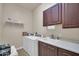 Functional laundry room with a sink, wooden cabinets, and washer and dryer at 3125 W Desert Ln, Laveen, AZ 85339