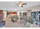 Open-concept living room featuring plush leather furniture, a ceiling fan, and seamless flow to kitchen at 3125 W Desert Ln, Laveen, AZ 85339