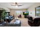 Open living room features a ceiling fan, media center, and comfortable leather seating at 3125 W Desert Ln, Laveen, AZ 85339