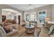 Stylish living space with wood floors, plush seating, and seamless connectivity to a formal dining area at 3125 W Desert Ln, Laveen, AZ 85339