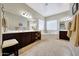 Bright main bathroom with dark wood cabinets, a large mirror, and a soaking tub in the corner at 3125 W Desert Ln, Laveen, AZ 85339