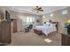 Generous main bedroom featuring plush carpeting, a ceiling fan, and shuttered windows for ample natural light at 3125 W Desert Ln, Laveen, AZ 85339