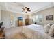 Airy main bedroom boasts a ceiling fan, king bed, shuttered windows, and a television on a wooden cabinet at 3125 W Desert Ln, Laveen, AZ 85339