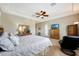 Spacious main bedroom with a ceiling fan, tray ceiling, television, and a comfortable looking king bed at 3125 W Desert Ln, Laveen, AZ 85339