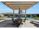 Covered patio with dining table, offering a picturesque view of the pool and backyard at 3125 W Desert Ln, Laveen, AZ 85339