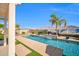 Gorgeous pool with water feature, surrounded by artificial turf and vibrant desert landscaping at 3125 W Desert Ln, Laveen, AZ 85339