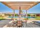 Relaxing poolside under a pergola with seating and a table with views of the landscape at 3125 W Desert Ln, Laveen, AZ 85339