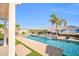 Sparkling pool with a water feature is surrounded by concrete, turf, and a block wall fence for privacy at 3125 W Desert Ln, Laveen, AZ 85339