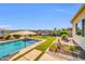 A beautiful swimming pool with artificial turf and rock landscaping is in a fenced-in yard at 3125 W Desert Ln, Laveen, AZ 85339