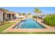 Refreshing pool with beach entry, lounge chairs, patio, shade and stunning views of a lush landscape at 3125 W Desert Ln, Laveen, AZ 85339