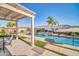A large swimming pool is surrounded by patio and synthetic grass and includes a pergola with seating at 3125 W Desert Ln, Laveen, AZ 85339