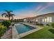 Inviting pool features a water feature, artificial turf and an adjacent covered patio for relaxing and entertaining at 3125 W Desert Ln, Laveen, AZ 85339