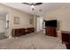 Large bedroom with plush carpet, ceiling fan, and vintage wooden furnishings and artwork at 35919 N Loemann Dr, San Tan Valley, AZ 85143