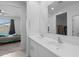 Bathroom vanity with double sinks, a large mirror, and an attached bedroom and walk-in closet at 36987 N Sidewinder Dr, San Tan Valley, AZ 85140