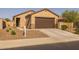 Single-story home with a brown garage door, desert landscaping, and a view of the front door entrance at 36987 N Sidewinder Dr, San Tan Valley, AZ 85140