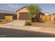 View of a single-story home with a two-car garage door, desert landscaping, and a tree in the front yard at 36987 N Sidewinder Dr, San Tan Valley, AZ 85140